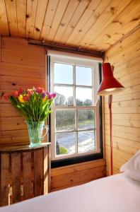 a bedroom with a vase of flowers in a window at Kiln Wing, Old Corn Mill in Bushmills