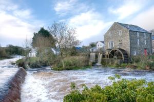 an old stone building next to a river at Kiln Wing, Old Corn Mill in Bushmills +15 photos