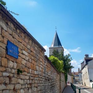 una pared de piedra con un letrero de la calle y un campanario de la iglesia en La Bonbonniere - Sure Hotel Collection by Best Western en Dijon