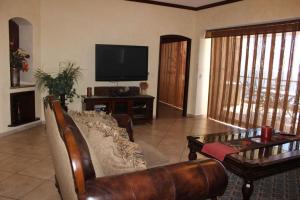 a living room with a couch and a tv at Sonoran Sky 3BR Upper Jacuzzi SKY 702-V by Casago in Puerto Peñasco
