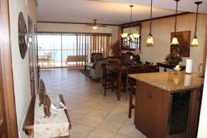 a kitchen and living room with a cat sitting on a chair at Sonoran Sky 3BR Upper Jacuzzi SKY 702-V by Casago in Puerto Peñasco