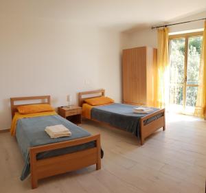 um quarto com 2 camas e uma grande janela em Marea Retreat Apartments em Marina di Camerota