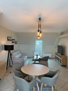 a living room with a table and chairs at Boulogne sur mer: Appartement de 70 m2 bien situé in Boulogne-sur-Mer