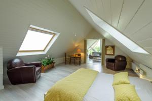 a attic bedroom with a bed and two chairs at Villa Marine in Plouguin +71 photos