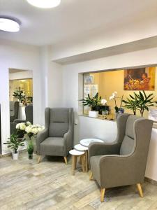 a waiting room with two chairs and a table at Iassium Residence Iasi in Iaşi