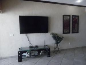 einen Flachbild-TV an der Wand mit einer Katze unter einem Tisch in der Unterkunft Sonoran Sky 1BR Upper SKY 405-V by Casago in Puerto Peñasco