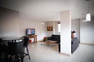 un soggiorno con un divano e un tavolo di Blu Terrace Hotel a Blumenau