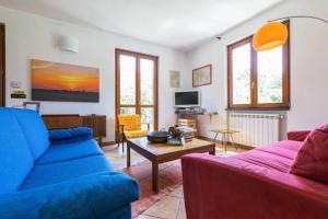 Charming Ligurian Riviera House في فينالي ليغوري: غرفة معيشة مع أريكة زرقاء وطاولة
