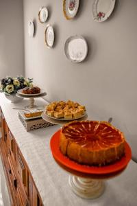 una mesa con un pastel y platos en la pared en Blu Terrace Hotel, en Blumenau