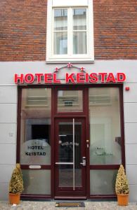 
a red and white sign in front of a building at Hotel Keistad in Amersfoort

