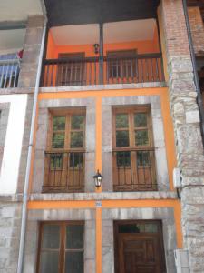 um edifício com um monte de portas e janelas em El Capricho em Cue