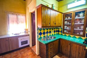 アラウリン・エル・グランデにあるCubo's Villa Soniaのキッチン(木製キャビネット、シンク付)