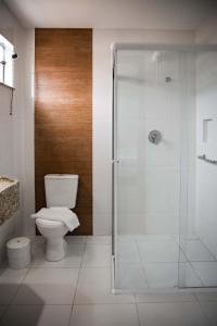 a bathroom with a toilet and a glass shower at Blu Terrace Hotel in Blumenau