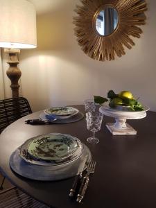 a table with plates and glasses and a mirror at Ihr neuer Lieblingsplatz in Meran in Merano