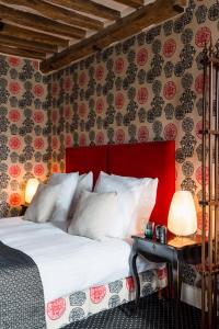 パリにあるホテル ル ルレ サン ジェルマンのベッドルーム1室(赤いヘッドボード付きの大型ベッド1台付)