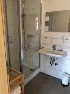 bagno con doccia e lavandino di Landgasthaus zum Altwirt Reichersbeuern a Reichersbeuern