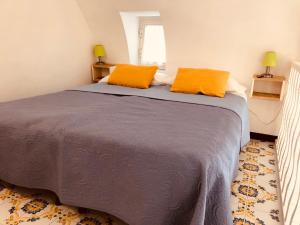a bedroom with a bed with two orange pillows on it at a Casa dei Sasso in Positano
