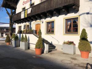 a building with potted plants in front of it at Landgasthaus zum Altwirt Reichersbeuern in Reichersbeuern