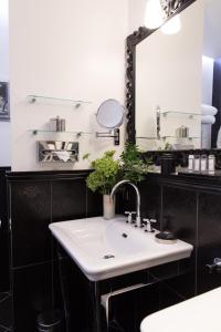 bagno con lavandino e specchio di Hôtel Le Relais Saint-Germain a Parigi