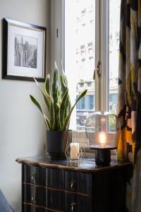 un tavolo con una pianta in vaso e una candela sopra di Hôtel Le Relais Saint-Germain a Parigi