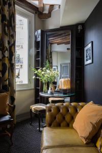 a living room with a couch and a mirror at Hôtel Le Relais Saint-Germain in Paris