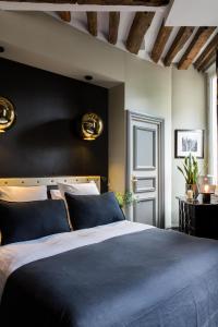 a bedroom with a blue bed and a black wall at Hôtel Le Relais Saint-Germain in Paris