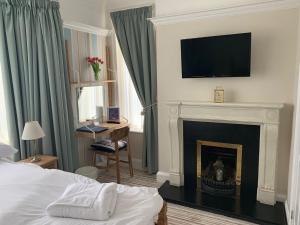 a bedroom with a fireplace with a television above it at Holly Trees in Seahouses
