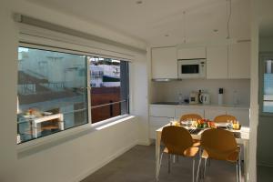 a kitchen with a table and chairs and a window at APARTAMENTO MAR WITH PARKINg in Sesimbra