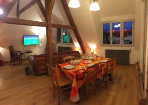 a dining room with a table with orange table cloth at Les Citadines in Amboise
