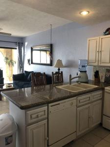 eine Küche mit einem Waschbecken und ein Wohnzimmer in der Unterkunft Sonoran Sea 1BR SSE 510 by Casago in Puerto Peñasco