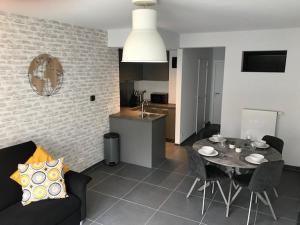 eine Küche und ein Wohnzimmer mit Tisch und Stühlen in der Unterkunft Residentie Sorrento in Middelkerke