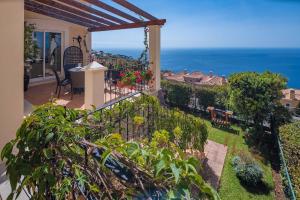 a balcony of a house with a view of the ocean at Designed Villa Palheiro Village by Holiday Rental Madeira in Funchal