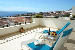 a patio with a table and chairs on a balcony at Apartments Villa Azzurra Bol in Bol