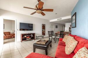 a living room with a red couch and a ceiling fan at Sonoran Sea 2BR SSW 606 by Casago in Puerto Peñasco