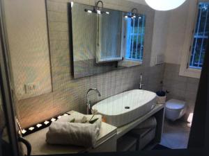 a bathroom with a white sink and a toilet at Jesolo pineta oasi verde ,spiaggia e mare in Lido di Jesolo