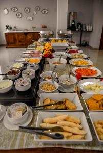 a buffet with many plates of food on a table at Blu Terrace Hotel in Blumenau