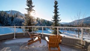 a balcony with two chairs and a view of the mountains at THE LOOKOUT PENTHOUSE // a luxe suite in Whistler in Whistler