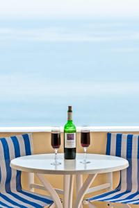 a white table with two glasses of red wine at Artemis Village in Karterados