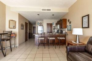 een woonkamer en een keuken met een bank en een tafel bij Sonoran Sea 1BR SSW 510 by Casago in Puerto Peñasco