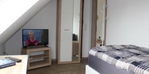 a bedroom with a bed and a television on a table at Schünenbusch in Minden