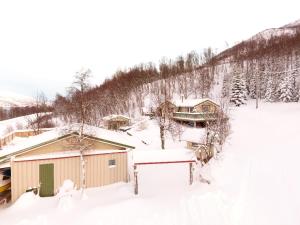 a house is covered in snow with trees at Marytun Cabins in Mortenhals