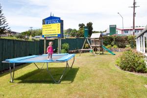 two children are playing in a green park at Accommodation at Te Puna Motel in Tauranga