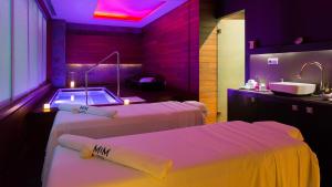 
a hotel room with two beds and a television at Hotel MiM Sitges & Spa in Sitges
