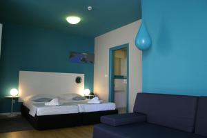 a blue bedroom with a bed and a couch at Apartments Villa Azzurra Bol in Bol +37 photos