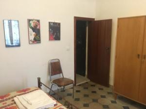 a bedroom with a bed and a chair next to a door at B&B Del Teatro in Sulmona