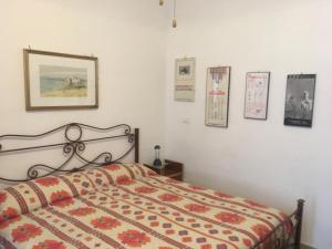 una camera da letto con un letto con un piumone e immagini appese al muro di B&B Del Teatro a Sulmona