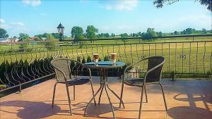 a table and chairs on a patio with a view of a field at Apartament na Górce in Mikołajki