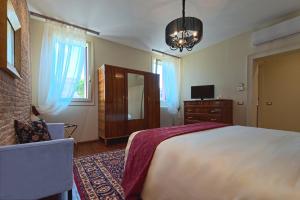 Un dormitorio con una cama grande y una lámpara de araña. en 28 Alla Rotonda, en Rovigo
