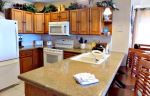 a kitchen with a sink and a white refrigerator at Sonoran Sea 3BR SSW 1006 Penthouse by Casago in Puerto Peñasco