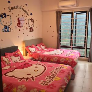 two beds in a room with hello kitty stickers on the wall at 12pax Golden Shine Homestay @Midhills Genting in Genting Highlands